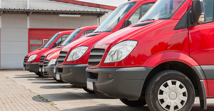 Six red vehicles lined up and parked next to each other.