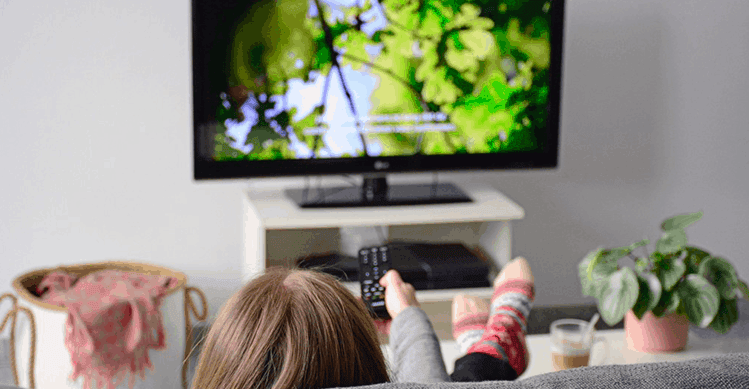 Person watching TV on the couch.