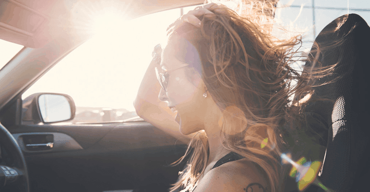 Girl driving car with the wind blowing in her hair.