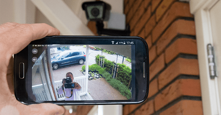 Person taking a photo of the stream from security camera on their phone.