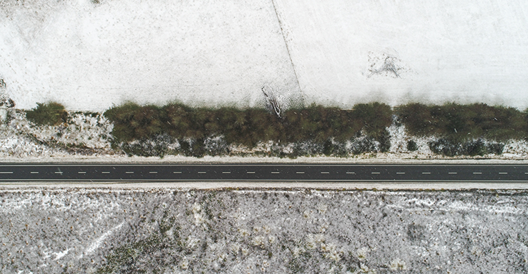 Overhead shot of a road covered in black ice.