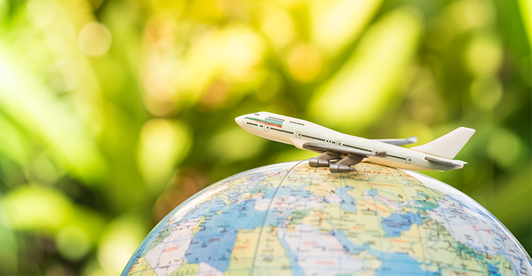 Airplane perched on top of a globe.